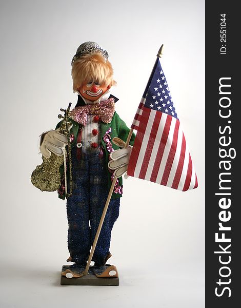 A statue of a clown holding an american flag. A statue of a clown holding an american flag