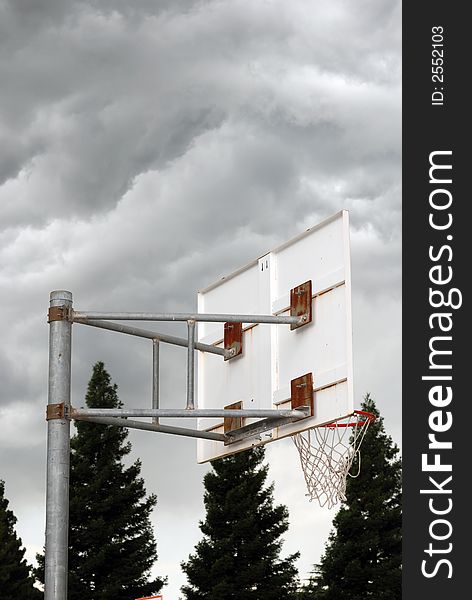 Basketball hoop with dark ominous clouds overhead. Basketball hoop with dark ominous clouds overhead