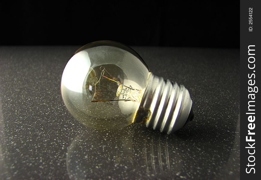A shot of a light bulb on granite. A shot of a light bulb on granite.
