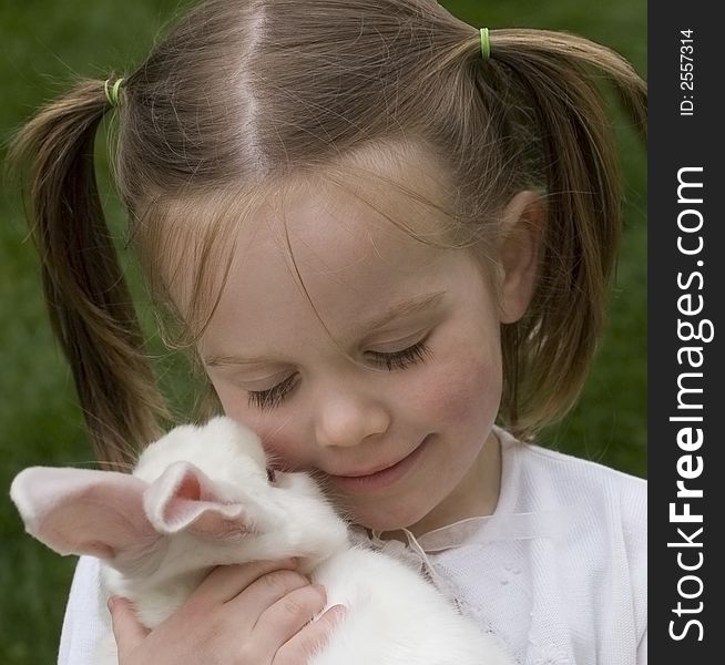 A young girl hugging a white Easter bunny. A young girl hugging a white Easter bunny