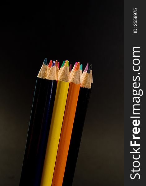 Color pencil group isolated over black background