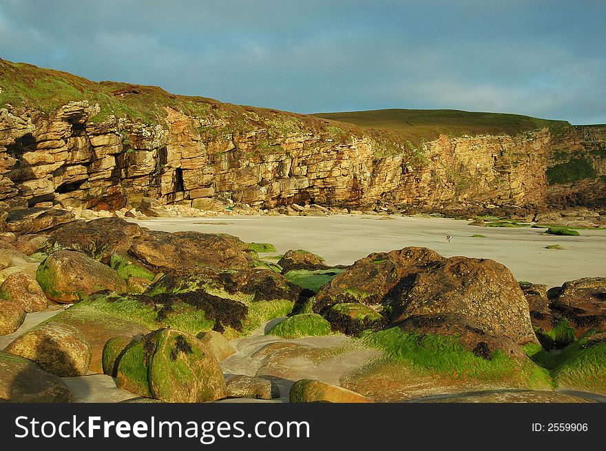 The landfall rocks and low cliffs showing erosion and geological formation of a rocky bay. The landfall rocks and low cliffs showing erosion and geological formation of a rocky bay.