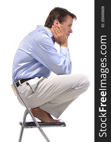 Side view of business man squatting barefoot on office chair with white background. Side view of business man squatting barefoot on office chair with white background