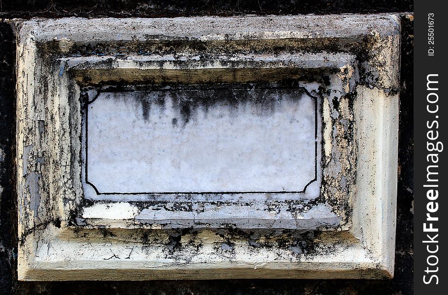 Old dirty and empty name board made of concrete and white marble stone with copy space for text. The nameplate is grungy and the paint is peeling off due to age and low maintenance. Old dirty and empty name board made of concrete and white marble stone with copy space for text. The nameplate is grungy and the paint is peeling off due to age and low maintenance.