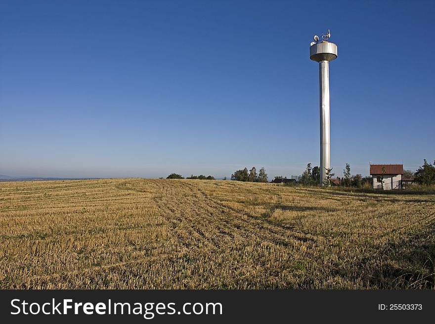 Large white water tower in farm field