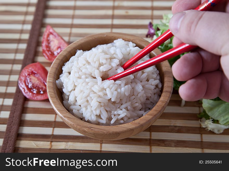 Hand holds chopstick with rice