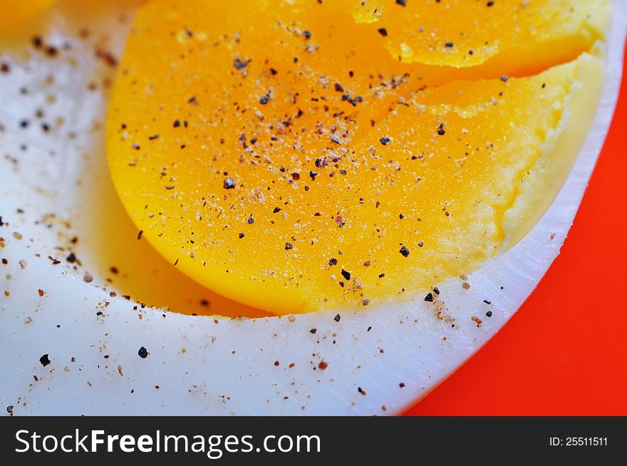 Macro of a boiled egg yolk with pepper, sprinkled on it. Macro of a boiled egg yolk with pepper, sprinkled on it