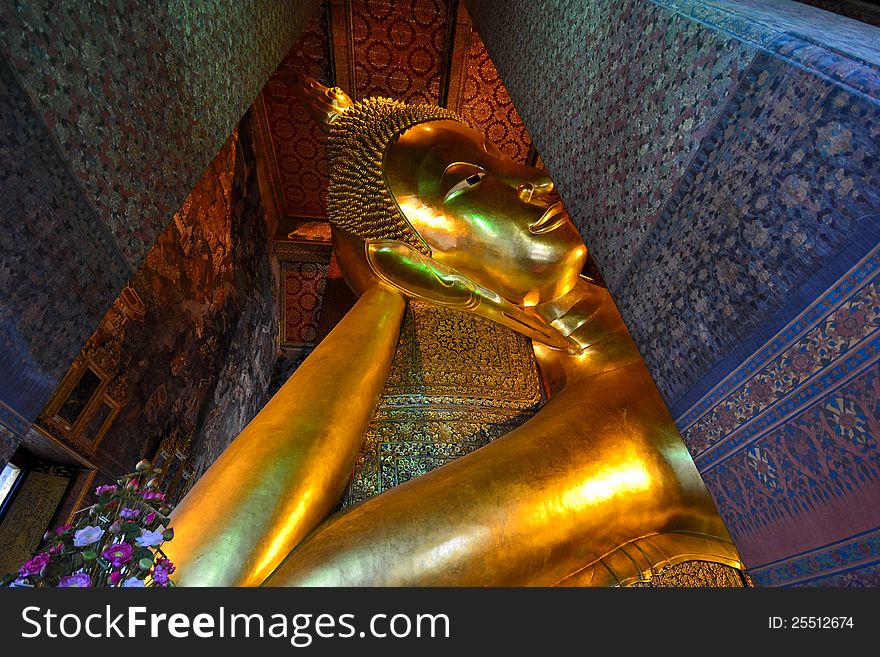 Golden reclining buddha image is surrounded by exquisite painting. Golden reclining buddha image is surrounded by exquisite painting