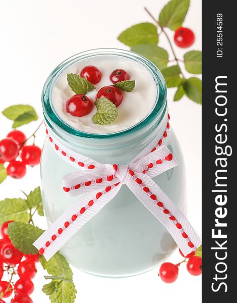 Redcurrant yoghurt with peppermint on white background