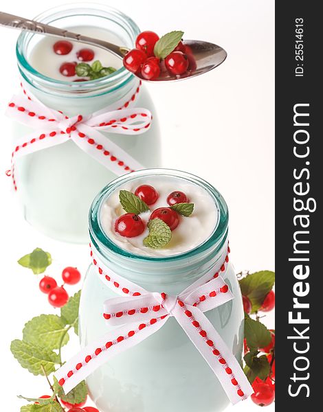 Redcurrant yoghurt with peppermint on white background