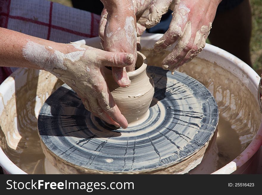 Potter at work. Making a vase.