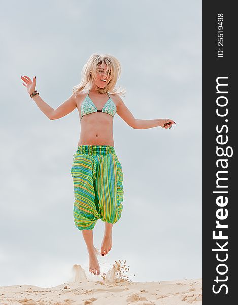 Young Girl Jumping In The Sand