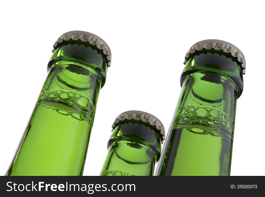 Three green bottle necks with crown caps, containing liquid, isolated on white background