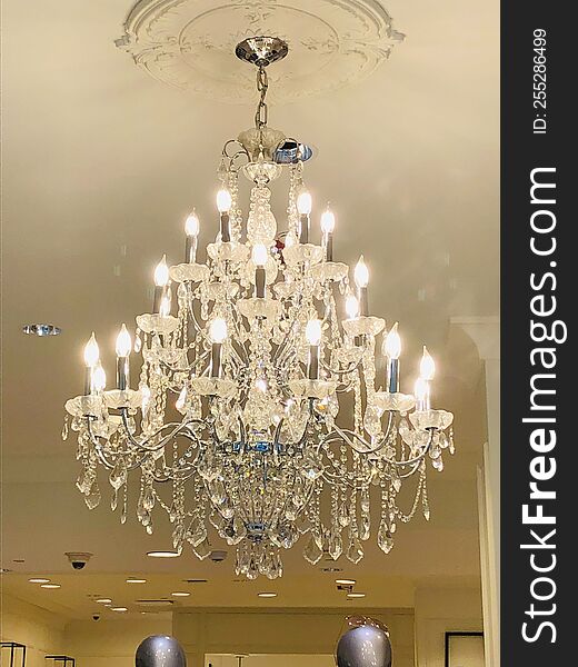 This beautiful white crystal chandelier hanging from ceiling with crystals all about and candle like lightbulbs. hanging from the ceiling. This beautiful white crystal chandelier hanging from ceiling with crystals all about and candle like lightbulbs. hanging from the ceiling.