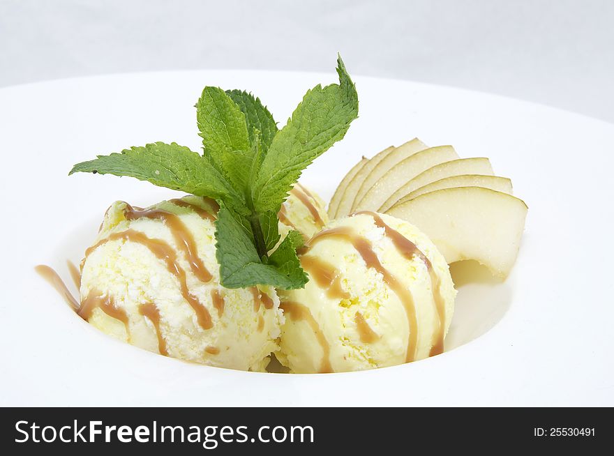 Ice cream with caramel sauce and mint on a white background. Ice cream with caramel sauce and mint on a white background