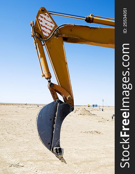 Bucket of excavator against the blue sky. Bucket of excavator against the blue sky