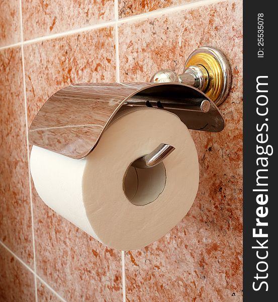 A Toilet roll holder with a tiled background