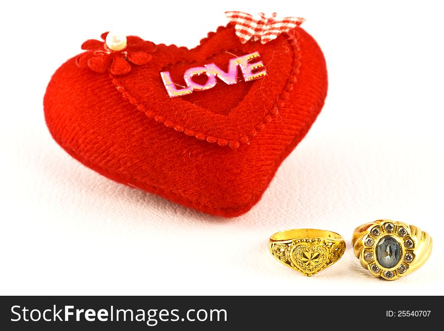 The golden rings and red heart on white background. The golden rings and red heart on white background.