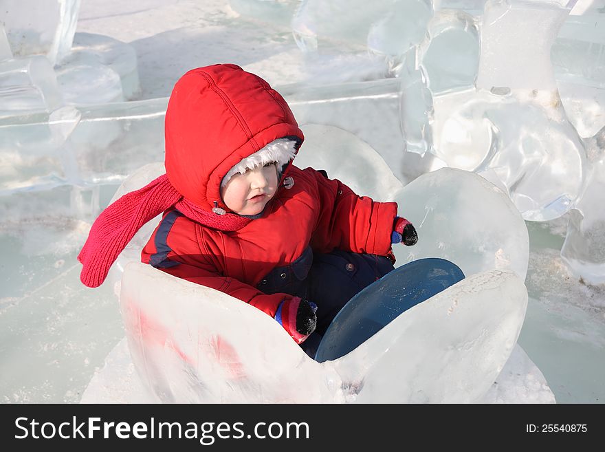 Little girl wearing warm jumpsuit sits in ice nenuphar at winter outdoor. Little girl wearing warm jumpsuit sits in ice nenuphar at winter outdoor