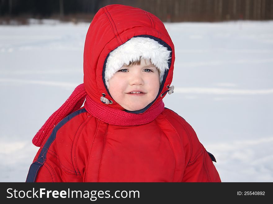 Little serious girl stands near forest at winter and looks into distance. Little serious girl stands near forest at winter and looks into distance