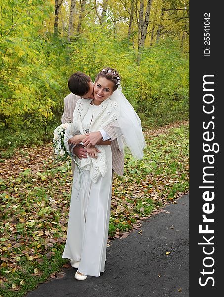 Young Groom Hugs His Bride And Kisses Neck