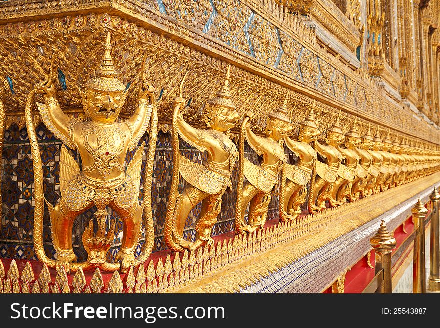 The statues of Garuda battling naga serpent on the wall of temple in Thailand. The statues of Garuda battling naga serpent on the wall of temple in Thailand