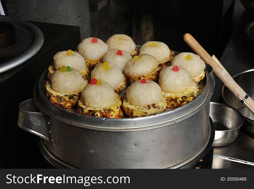 The chinese snack pineapple rice is a sweet sticky black glutinous rice in a hollowed out pineapple and tastes wonderful! The photo was taken in Chengdu city, Sichuan, China.