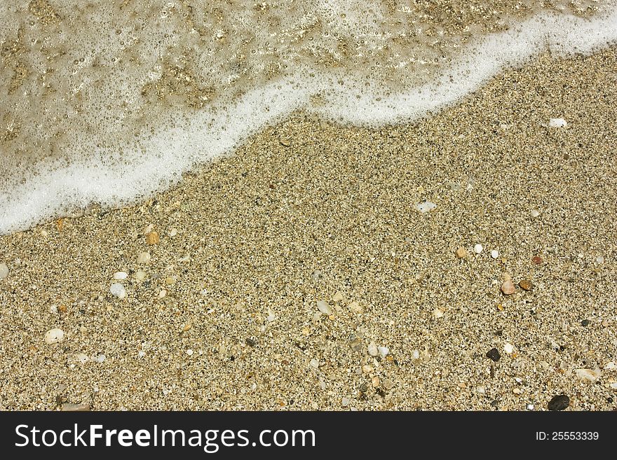 Close up on sand an wave on the beach. Close up on sand an wave on the beach