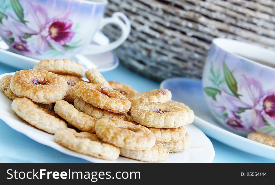 Tea time in the summer garden, tea porcelain cups and biscuits with marmalade