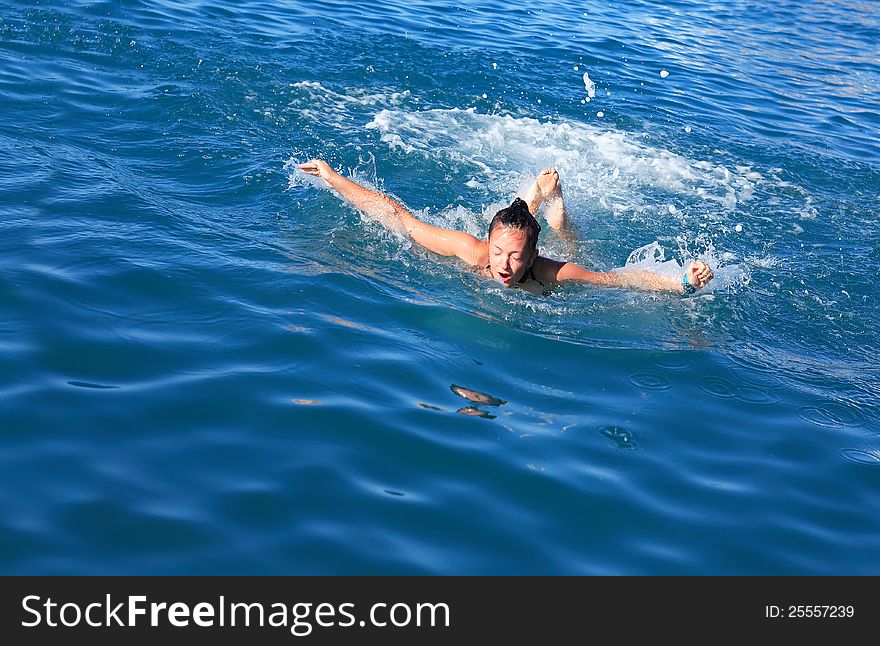 Beauty teenage girl swimming the butterfly stroke in a sea. Beauty teenage girl swimming the butterfly stroke in a sea