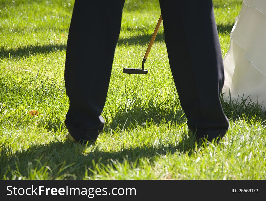 Golf cleek between bridegroomÂ´s legs. Golf cleek between bridegroomÂ´s legs