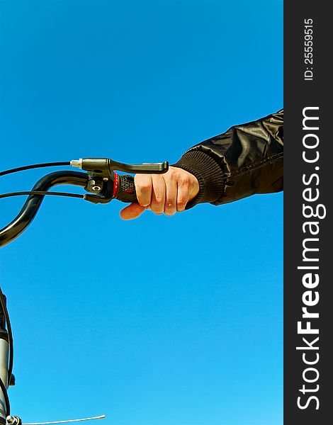 Man hand and part of bike on sky background. Man hand and part of bike on sky background.