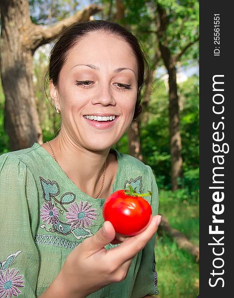 A young woman eating tomato. A young woman eating tomato