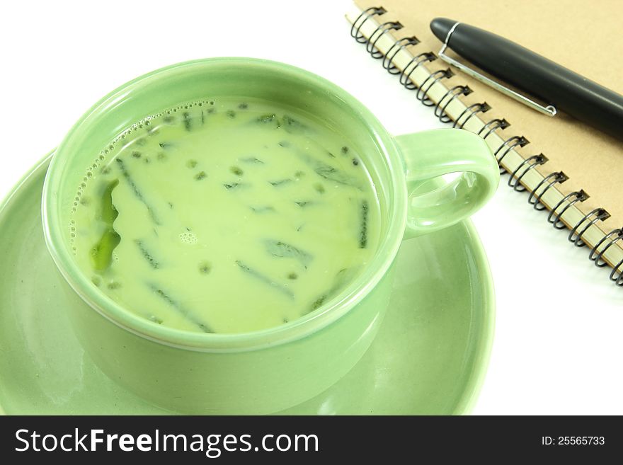 Soybean milk mixed green tea and notebook on white background