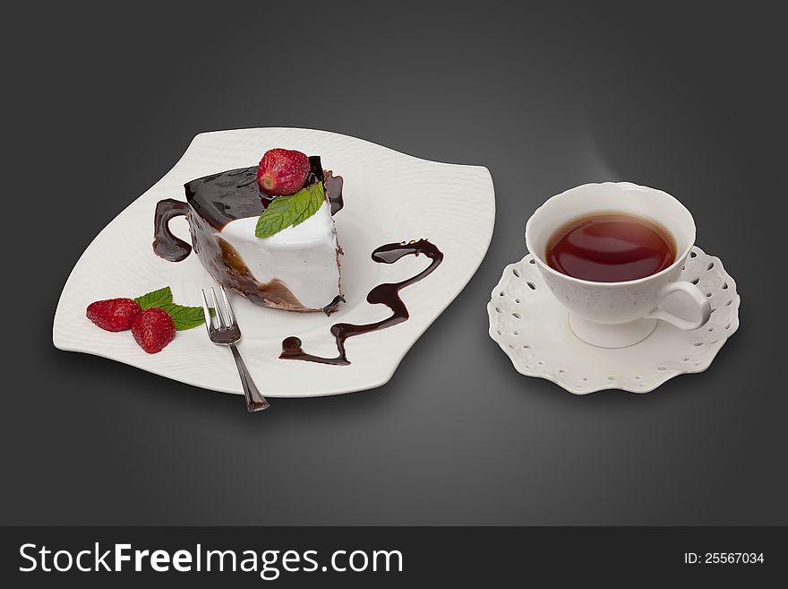 Chocolate cake served with strawberry and a cup of tea. Chocolate cake served with strawberry and a cup of tea