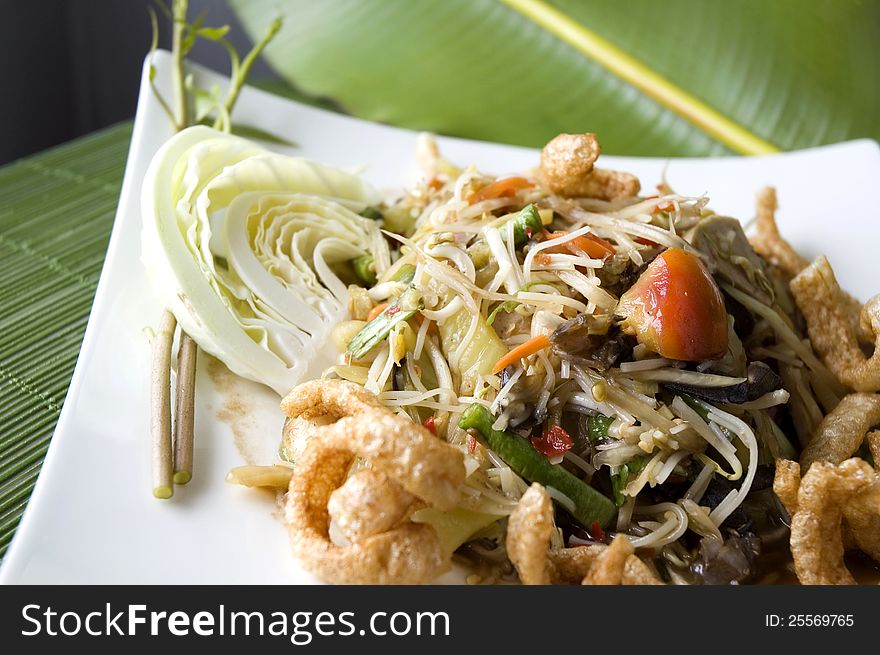 Close up spicy papaya salad on white plate