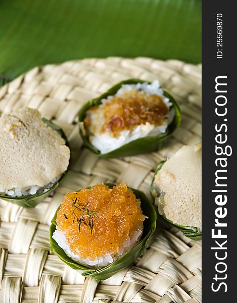 Thai native dessert. Sweet sticky rice with topping in banana leaf cup.