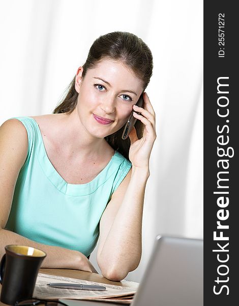 Young attractive business woman sitting at her desk. Young attractive business woman sitting at her desk