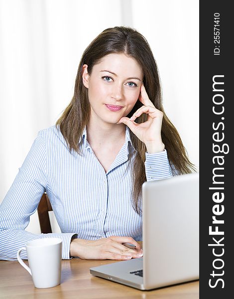 Young attractive business woman sitting at her desk. Young attractive business woman sitting at her desk