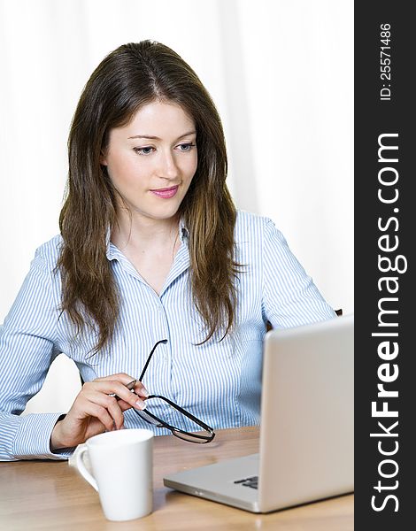 Young attractive business woman sitting at her desk. Young attractive business woman sitting at her desk