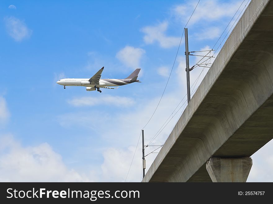 Two engines aircraft prepares for landing over skytrain railroad (airport link train), Bangkok, Thailand. Two engines aircraft prepares for landing over skytrain railroad (airport link train), Bangkok, Thailand