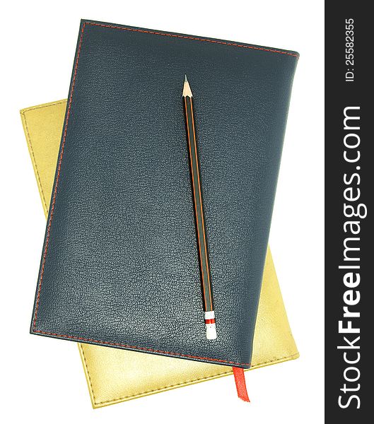 Stack of leather notebook and pencil