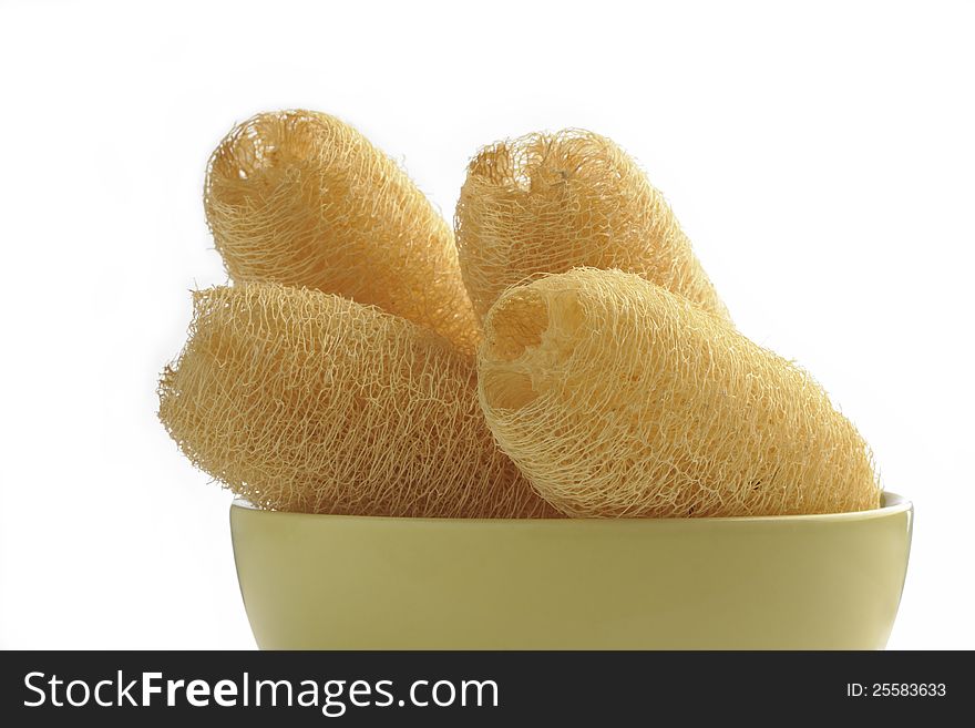 Loofah sponges with cup on white background