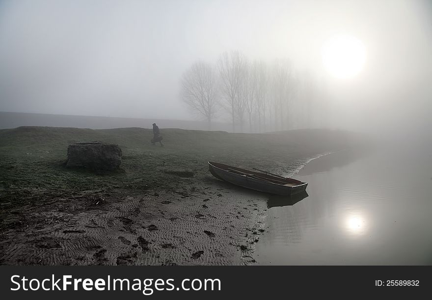 Misty Morning on the river Dniester. The boat on the shore. Heavy fog.