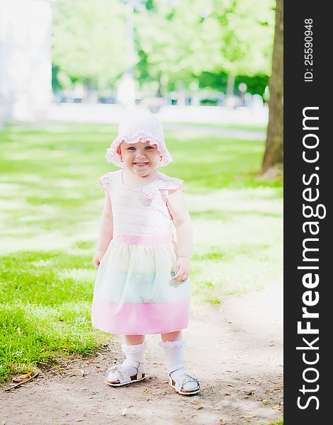 Toddler girl in pink dress and hat smiling and showing her tongue. Toddler girl in pink dress and hat smiling and showing her tongue