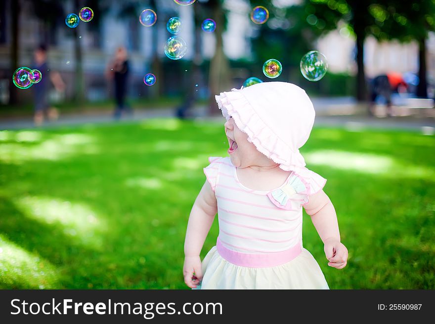 Little girl playing with soap bubbles outdoors. Little girl playing with soap bubbles outdoors