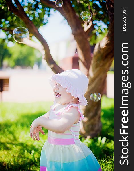 Little girl laughing while playing with soap bubbles. Little girl laughing while playing with soap bubbles