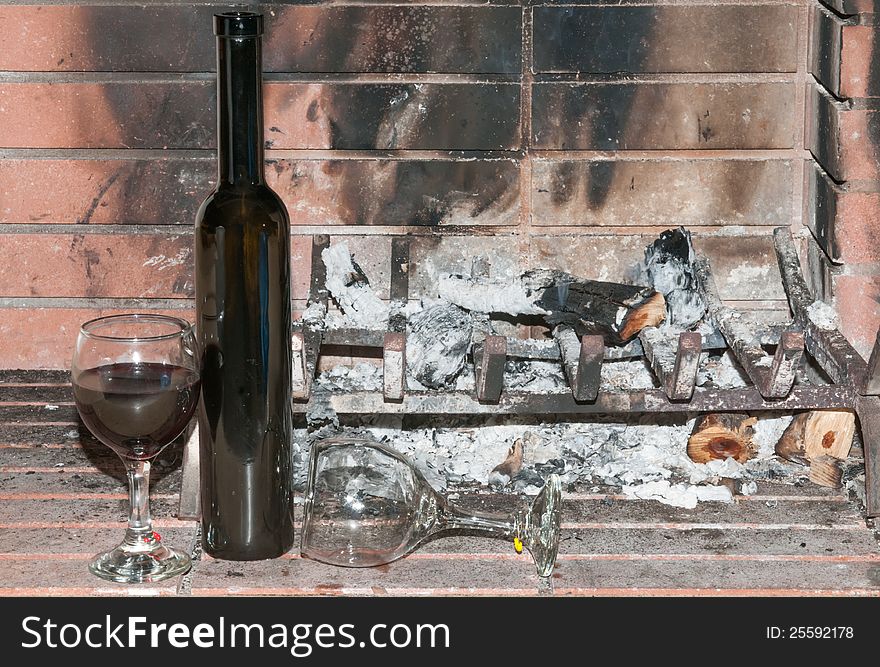Wineglasses one full and one empty by a dead cold fire. Wineglasses one full and one empty by a dead cold fire