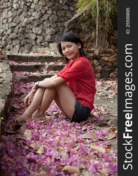 Asian Woman Sitting On Ground With Paper Flowers