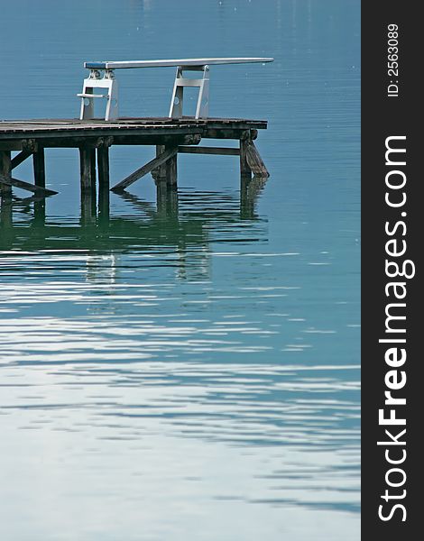 Diving board on the edge of a calm water level. Diving board on the edge of a calm water level